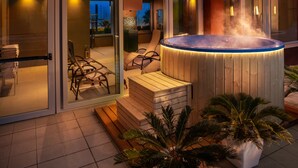 A modern outdoor hot tub area with wooden seating and a palm plant. - Hotel Ascot & Spa (Rimini)