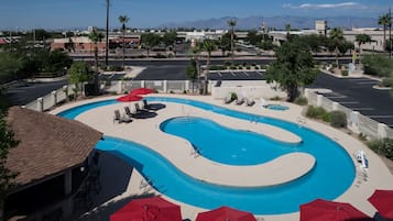 Una piscina al aire libre, sombrillas, sillones reclinables de piscina