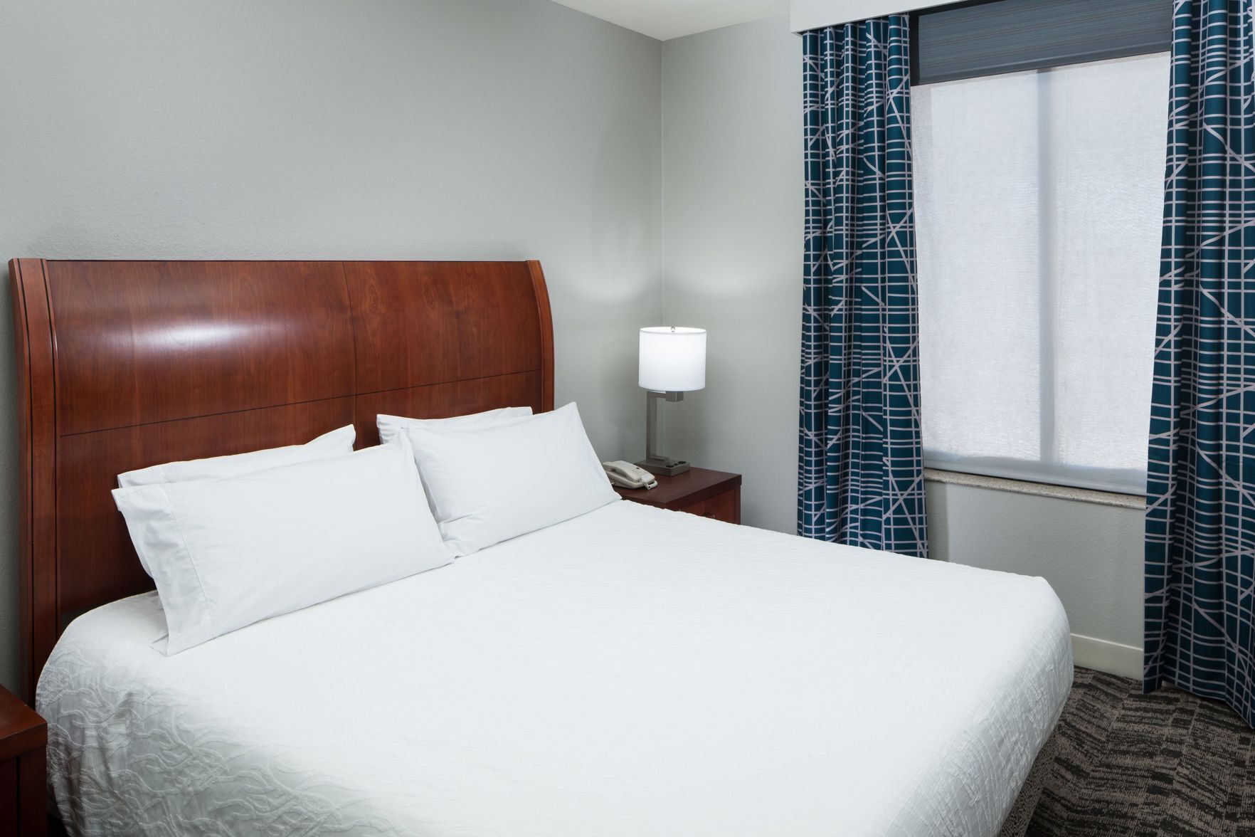 Premium bedding, desk, laptop workspace, blackout drapes