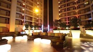 Vestíbulo de hotel con un amplio espacio de estar, varios balcones y una columna central.