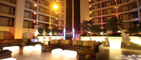 A hotel lobby with a large seating area, multiple balconies, and a central column.