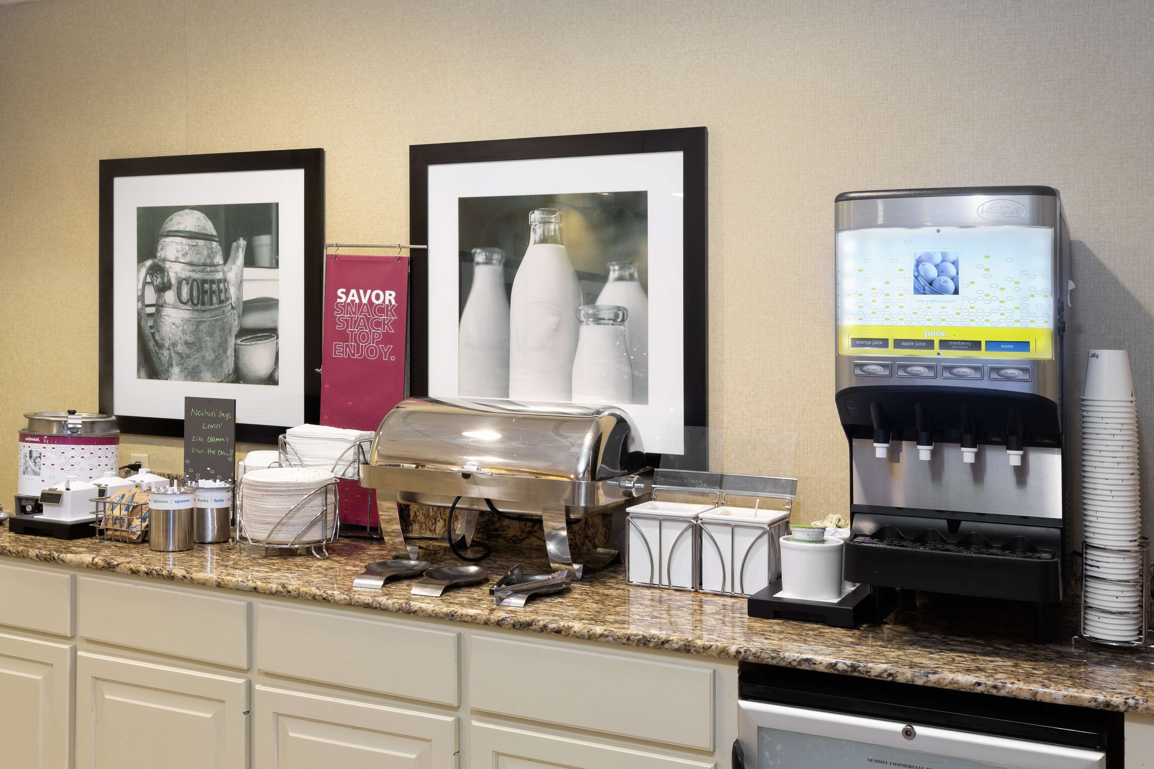 A coffee station with a coffee machine, milk frother, and various coffee containers.