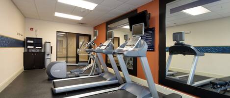 A gym with treadmills, a stationary bike, and a mirrored wall.