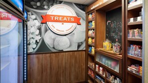 A bakery section with a sign reading "TREATS" and shelves stocked with various baked goods and snacks. - Hampton Inn & Suites Baton Rouge - I-10 East (Baton Rouge)