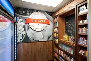 Una sección de panadería con un cartel que dice “TREATS” y estantes llenos de diversos productos horneados y bocadillos.