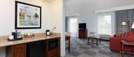A compact living space with a kitchenette, a dining area, and a seating area with a red sofa.