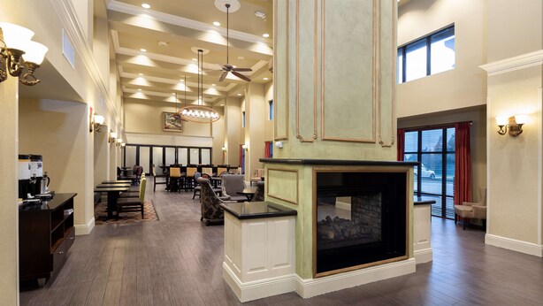 A spacious lobby with a fireplace, high ceilings, and modern lighting fixtures. - Hampton Inn & Suites Baton Rouge - I-10 East (Baton Rouge)