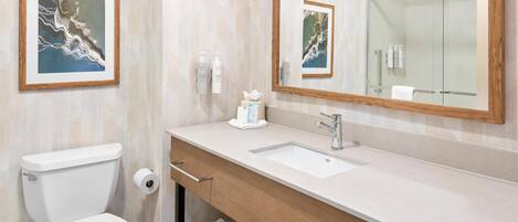 Une salle de bain moderne avec des toilettes, un lavabo et un grand miroir.