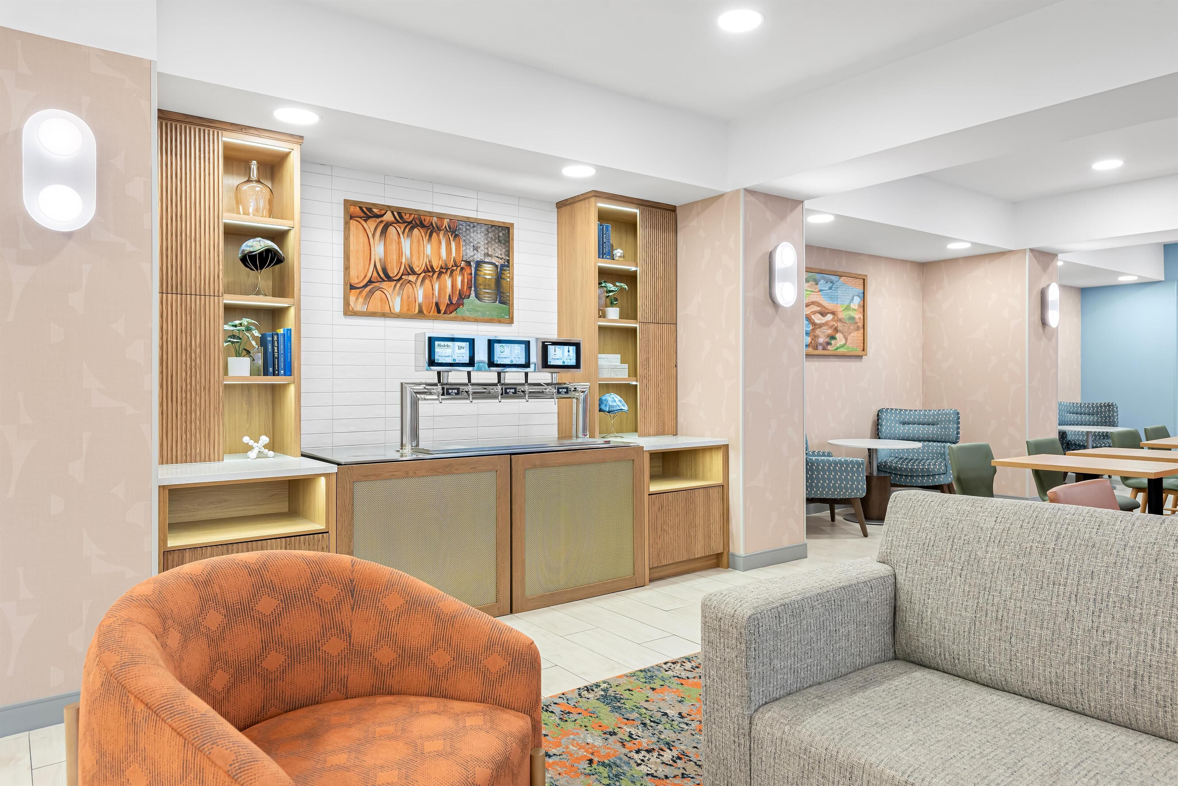 Eine moderne Hotelhalle mit einer Rezeption, einer Sitzecke und Kunstwerken.