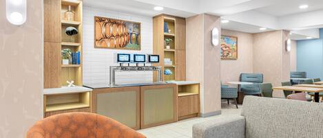 Eine moderne Hotelhalle mit einer Rezeption, einer Sitzecke und Kunstwerken.