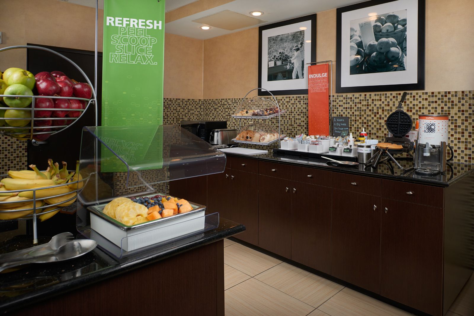 Uma área de buffet com diversas frutas e um espaço para café.