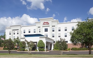 A white building with a sign reading 'Hampton Inn & Suites.'