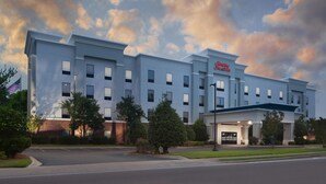 A modern hotel with a flat roof, multiple windows, and a prominent sign. - Hampton Inn & Suites Natchez (Natchez)