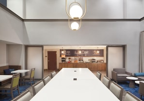 A conference room with a long table, chairs, a kitchenette, and a bar area.