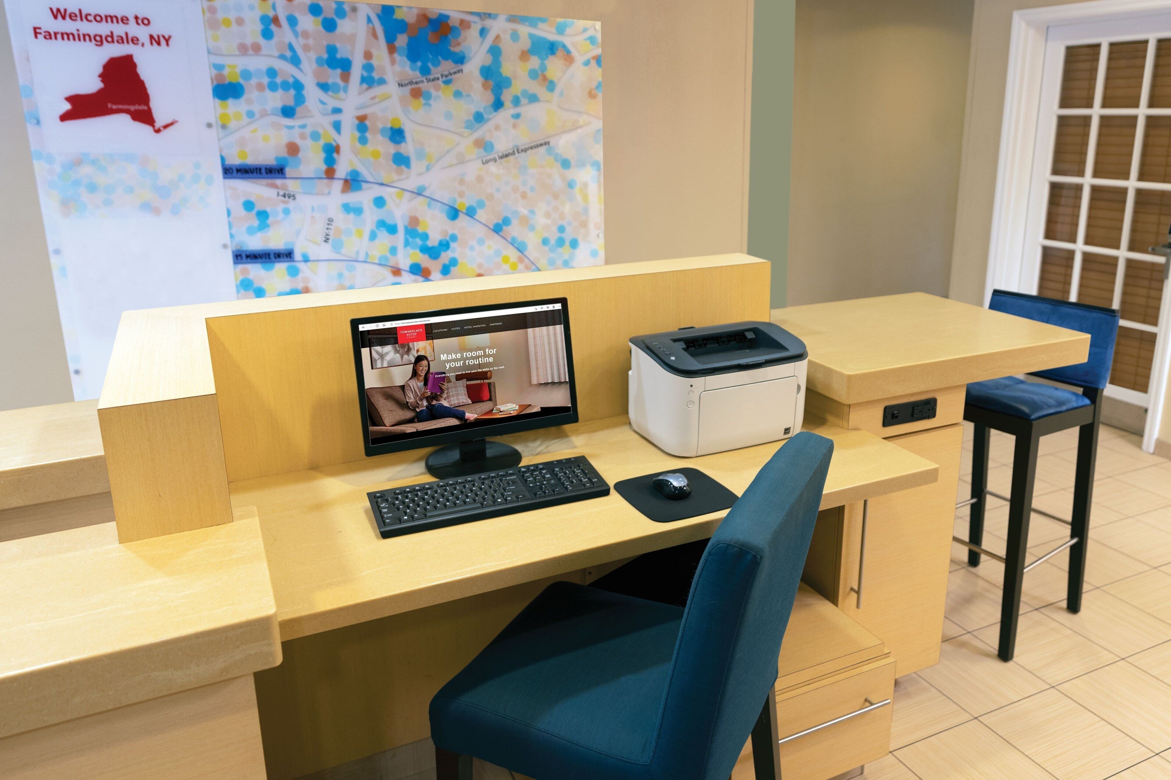 A reception desk with a computer, printer, and seating area.