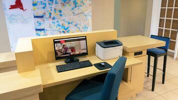 A reception desk with a computer, printer, and seating area.