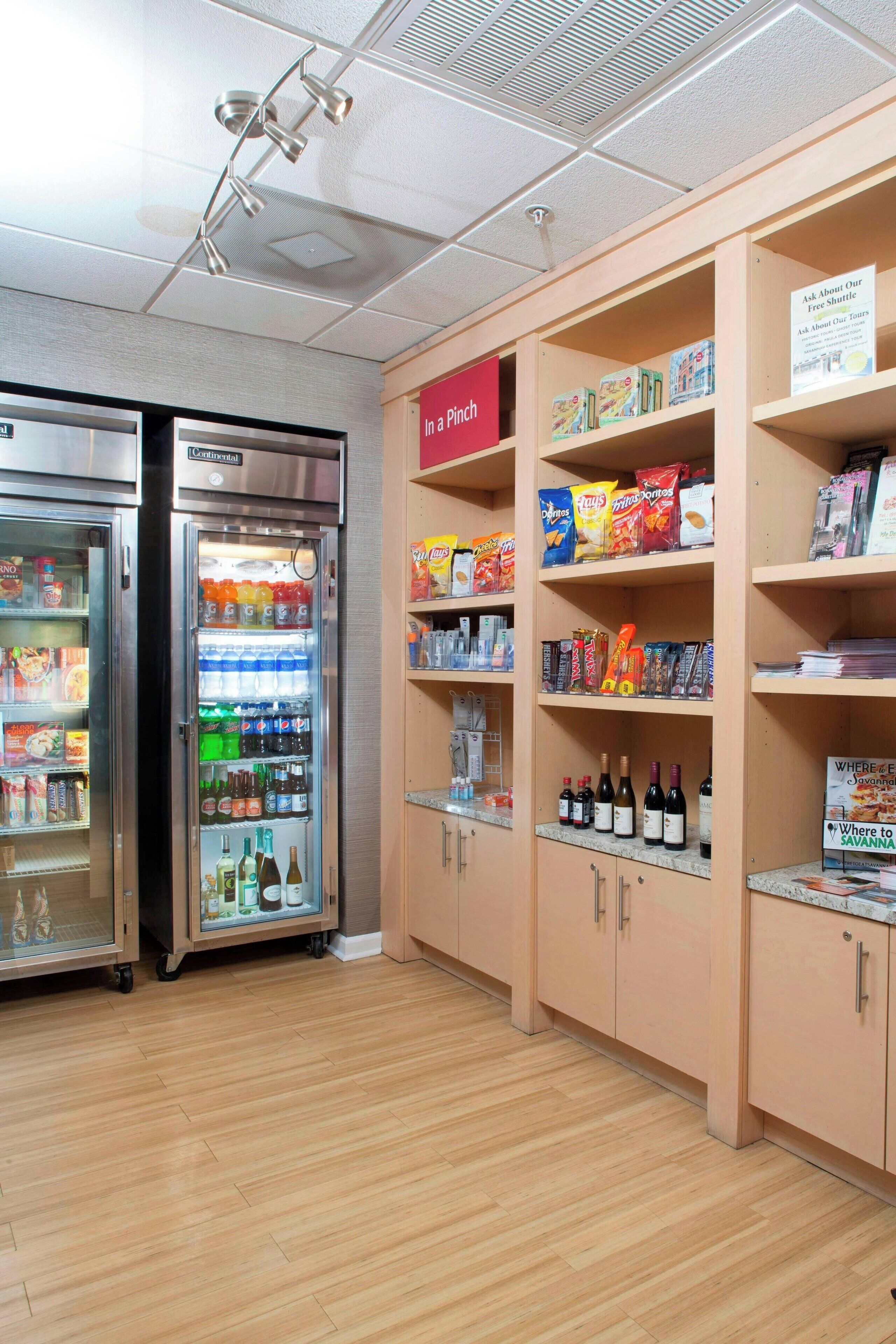 Zona de venta con opciones de comida y bebidas, que incluye un refrigerador y un congelador.