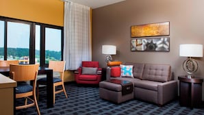 Une chambre d’hôtel comprenant un canapé, un fauteuil et un coin repas avec des chaises et une table.