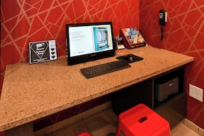 Check-in at our reception area, featuring a computer, keyboard, and printer, with a convenient telephone nearby.