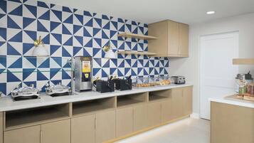 A modern kitchen with a geometric backsplash, built-in appliances, and a clean, organized layout.