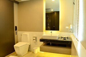Ein modernes Badezimmer mit Toilette, Waschbecken und Spiegel.