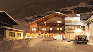 A multi-story hotel with a wooden facade, balconies, and a snow-covered landscape. - GB Gondelblick (Soelden)