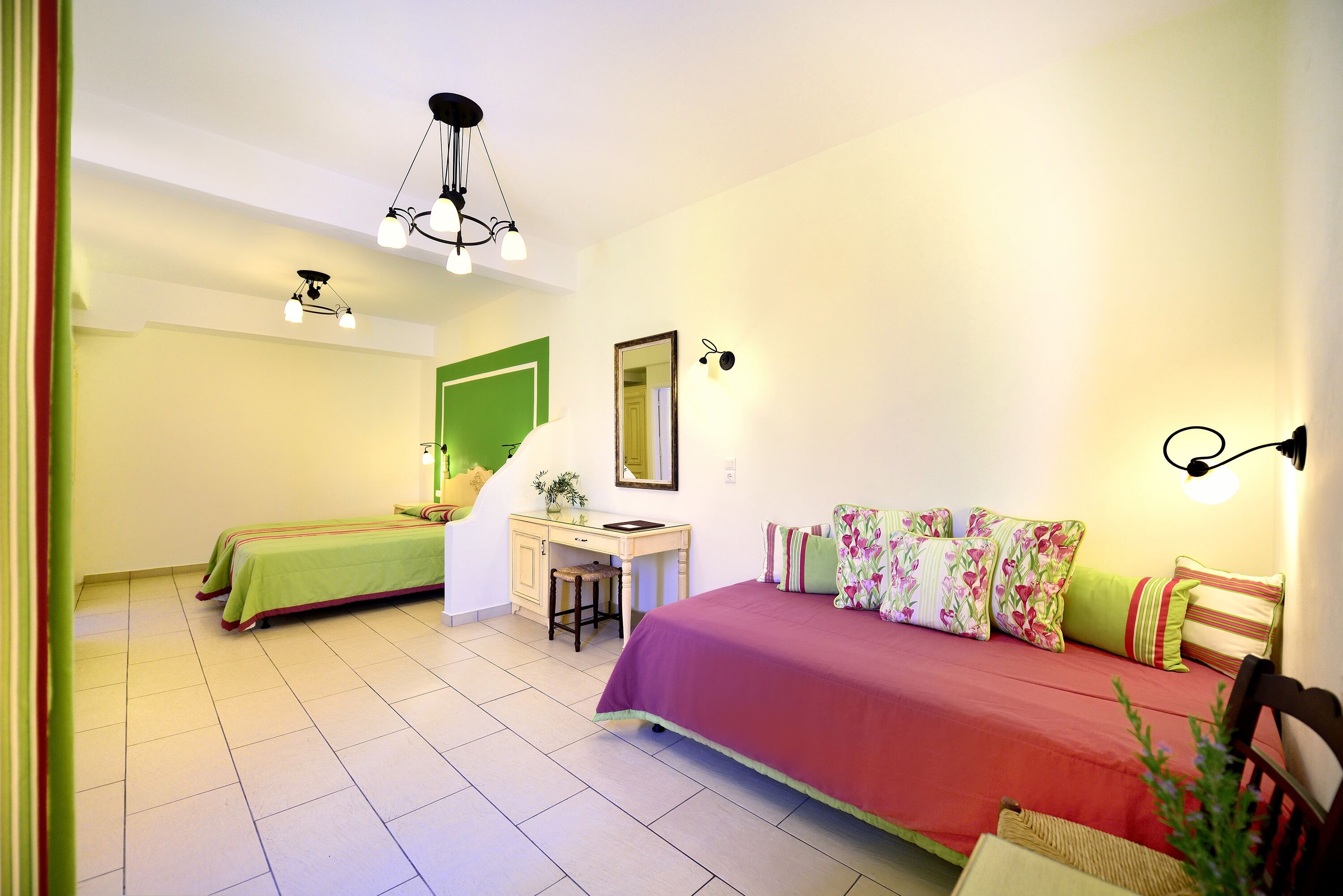 A bedroom with a bed, a desk, and a chair. There is a mirror on the wall and a plant on the desk.