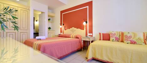A hotel room with two beds, a large mirror, and a red accent wall.