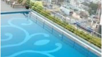 Una piscina al aire libre, sillones reclinables de piscina