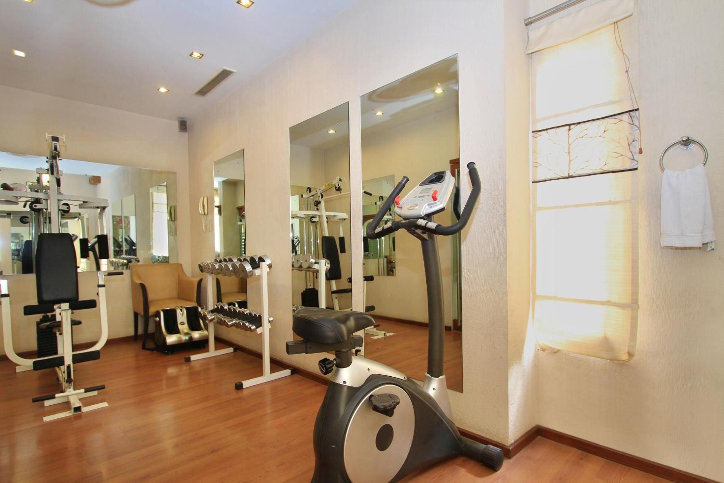 A gym with cardio equipment, weight machines, and mirrors.