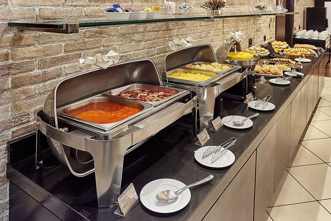 A buffet with various food items and utensils.