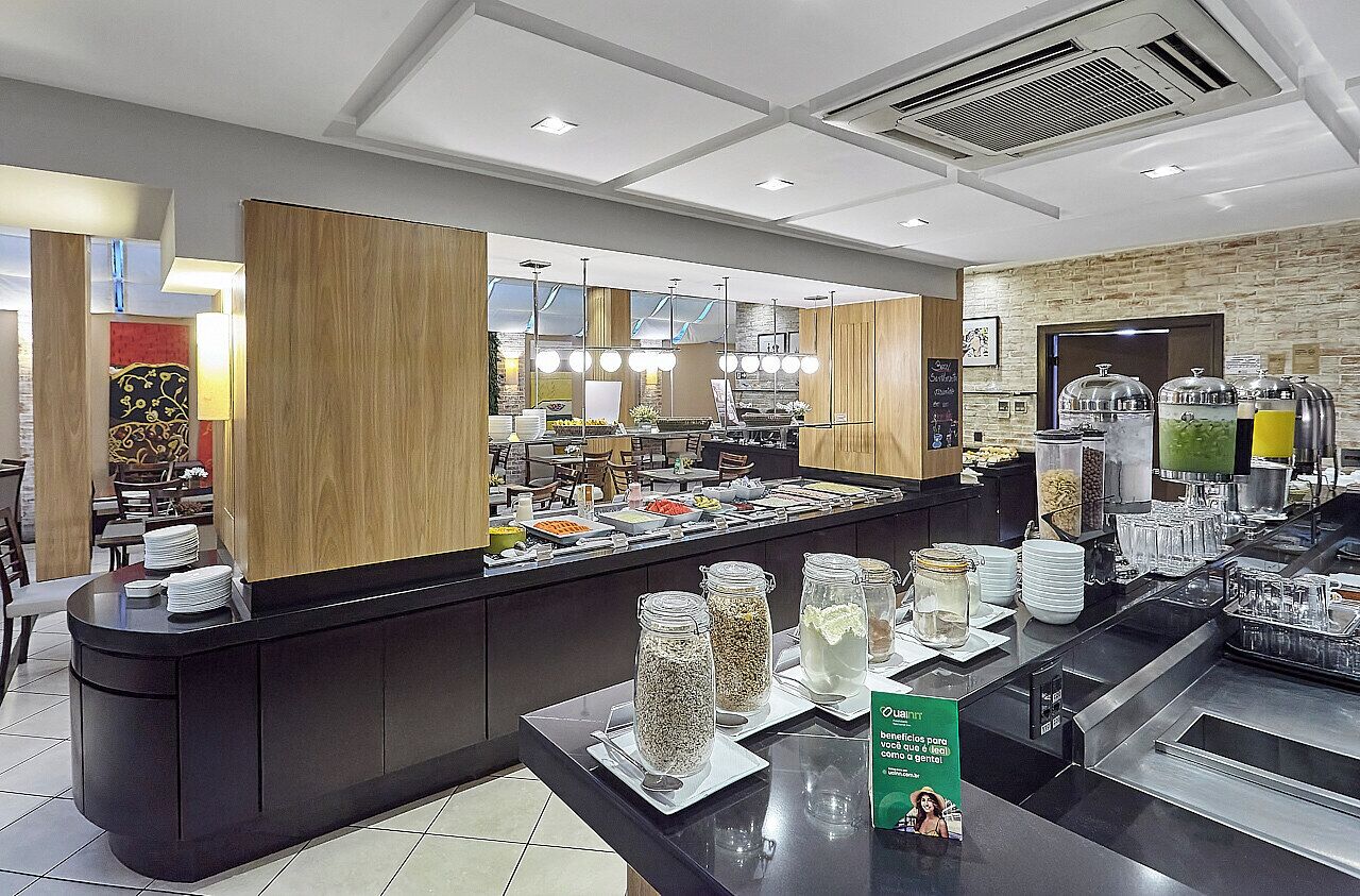 Un espace buffet proposant une variété de plats, un comptoir avec des assiettes et des couverts, et un panneau indiquant un avantage pour les clients.