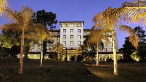 Un hotel de varios pisos con fachada simétrica, ventanas grandes y una entrada central.