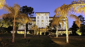 Stunning hotel entrance with manicured lawns and palm trees.