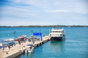 Un muelle con barcos amarrados, una señal y una vista despejada del agua y la tierra distante.