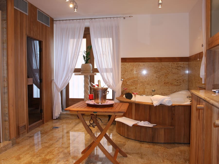 A modern bathroom with a wooden vanity, a bathtub, and a large mirror.