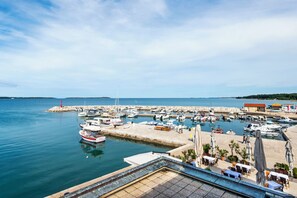 Un puerto deportivo con barcos amarrados, un muelle y un restaurante con terraza.