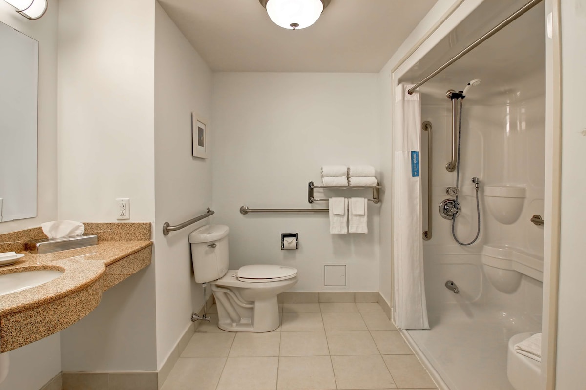 A modern bathroom with a toilet, sink, and shower area.