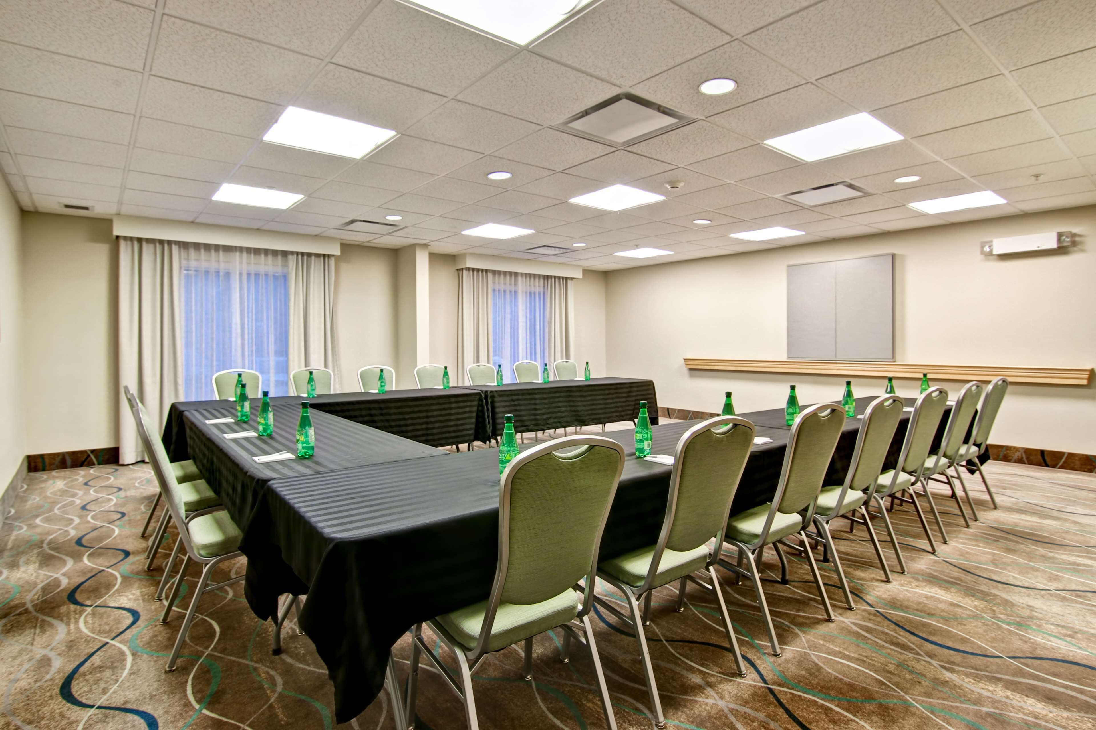 A conference room with a long table, chairs, and water bottles.