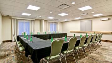A conference room with a long table, chairs, and water bottles.