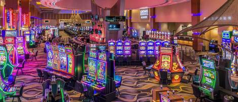 Ein Casino mit mehreren Spielautomaten und einer Bar.
