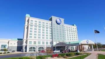 Un hotel grande con un llamativo letrero 'dle', múltiples ventanas y una entrada cubierta.