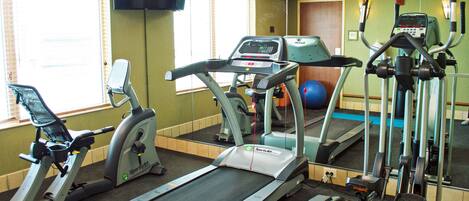 A gym with treadmills, an elliptical, and a stationary bike.