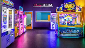 An arcade area with various gaming machines, a 'Party Room' sign, and a 'Ticket Coaster' game.