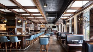 A modern bar area with wooden beams, bar stools, and a counter. - Four Points by Sheraton Victoria Gateway (Victoria)