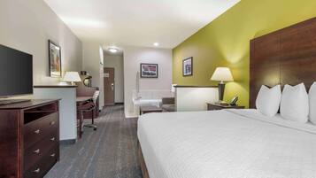 Hotelkamer met een groot bed, een bureau met stoel, een televisie, een badkamer met bad en douche.