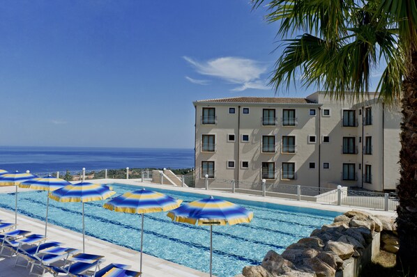 Seasonal outdoor pool, open 7 AM to 7 PM, pool umbrellas, pool loungers