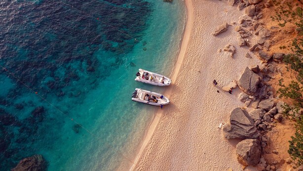 An aerial view of a beach with two boats anchored near the shore. - Hotel Brancamaria (Dorgali)