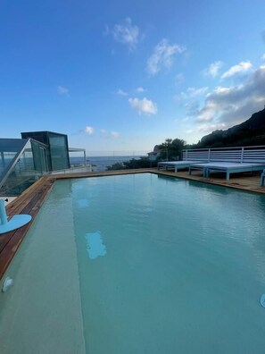 Una piscina techada, una piscina al aire libre de temporada, sombrillas