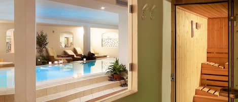 A spa area with a pool, lounge chairs, and a wooden sauna.